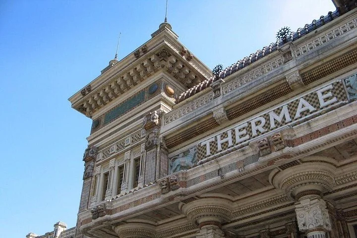The corner tower and upper facade of the Terme Berzieri with the word THERMAE in large letters
